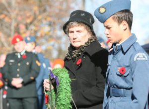 Viola Coghlan lays a wreath for her family members lost to conflict—Cyril, Eddie, Rogger and Jimmie. 